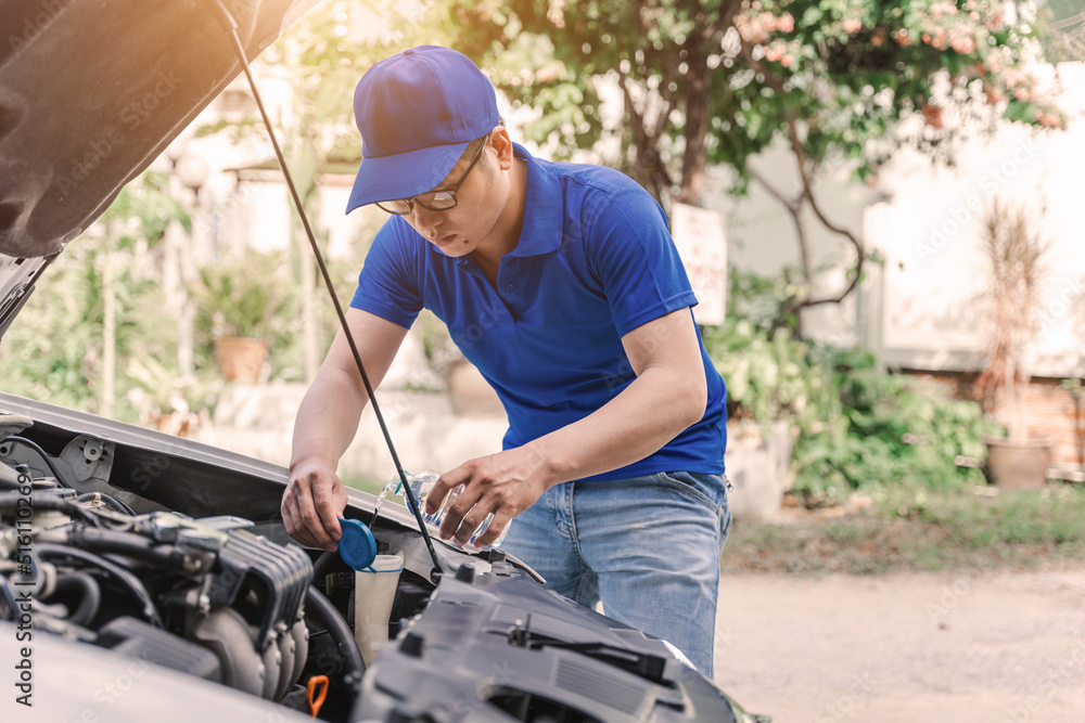 Close up Asian auto mechanic working in garage. Repair service.