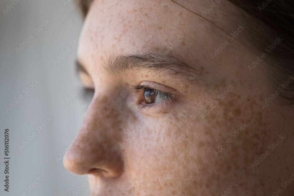 Fototapeta premium Side profile view face of freckled serious pensive woman staring aside. Close up cropped image of thoughtful young 18s female looking into distance. Concept of vision care, eyesight check up in clinic