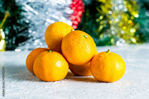 ripe tangerines on the table against the background of an elegant Christmas tree © сергей тарануха