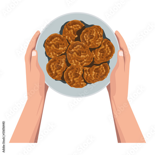 hands lifting cookies in dish