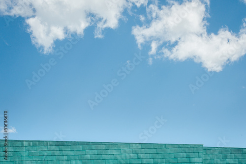 un bâtiment bleu devant un ciel bleu avec des nuages blancs. Détail d'un building moderne sous un ciel bleu d'été.