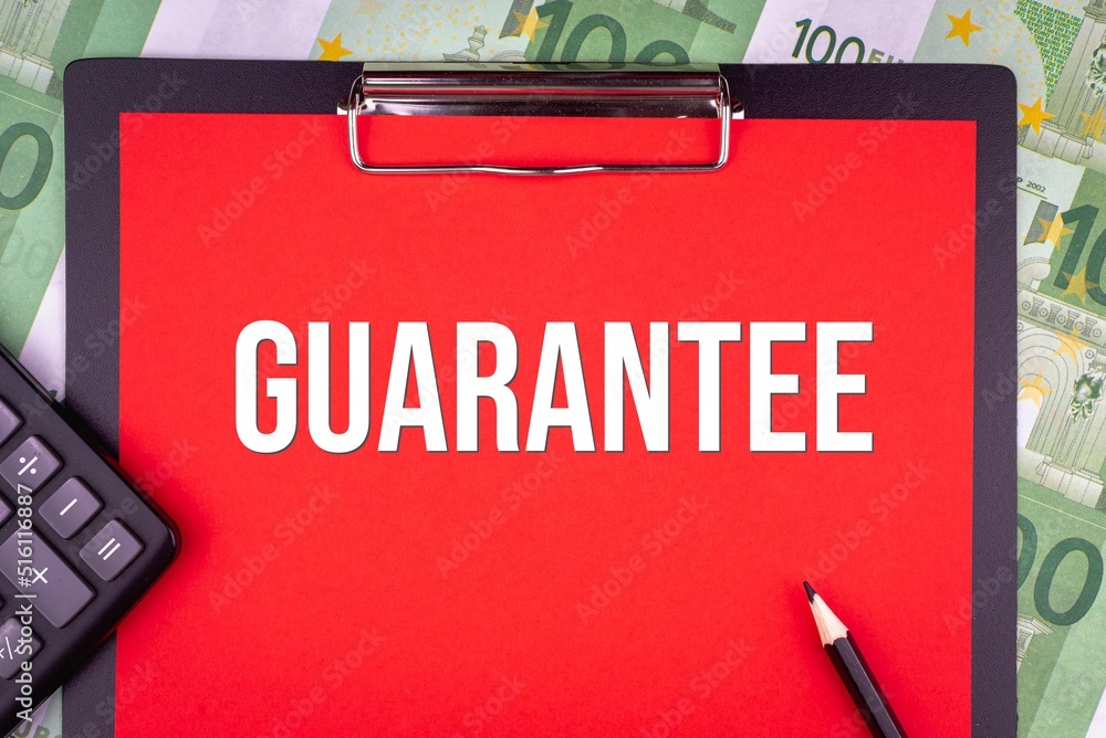 GUARANTEE - word on the background of money, a notepad and a pencil with a calculator. Business concept (copy space). GUARANTEE - word on the background of money, a notepad and a pencil with a calculator. Business concept (copy space).