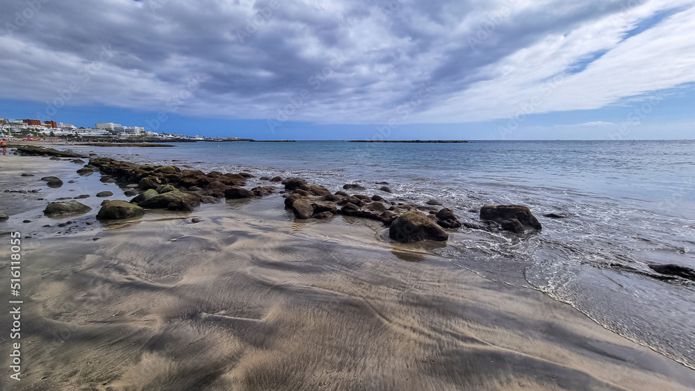 Scenic view on the drainage patterns at Costa Adeje beach on Tenerife, Canary Islands, Spain, Europe, EU. Amazing sand artistic sand patterns created from the incoming waves from the Atlantic Ocean