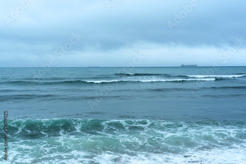 Nature background with sea waves hitting the sea shore. Scenic view of sea against cloudy sky © Rina Mskaya