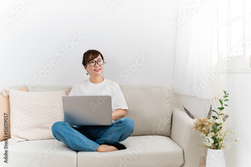 家のソファでパソコンを使う知的な日本人女性（メガネ）

