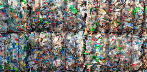 Close-up of a pile of compressed plastic waste at a waste recycling plant photo