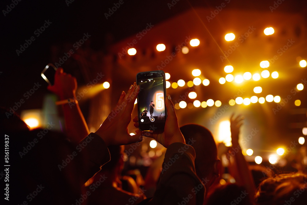 Using a smartphone in a public event, live music festival. Holding a mobile  phone in hands and shooting photo or video content. Youth, party, vacation  concept. Stock Photo | Adobe Stock