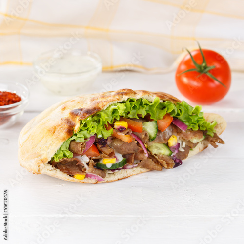 Döner Kebab Doner Kebap fast food in flatbread on a wooden board square