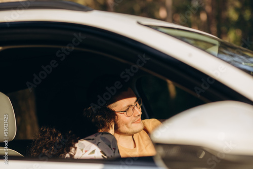 the happy couple man and woman in car traveling in summer