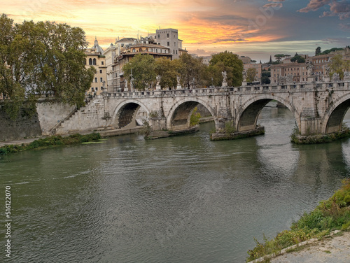 The Tiber river flows along with trees in sunny day, Rome, Italy.