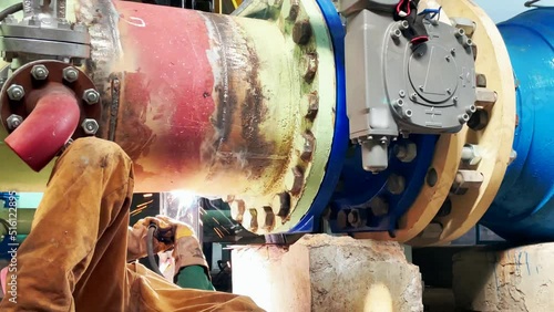 Welder performing an electrode welding of a 600 mm water pipe
