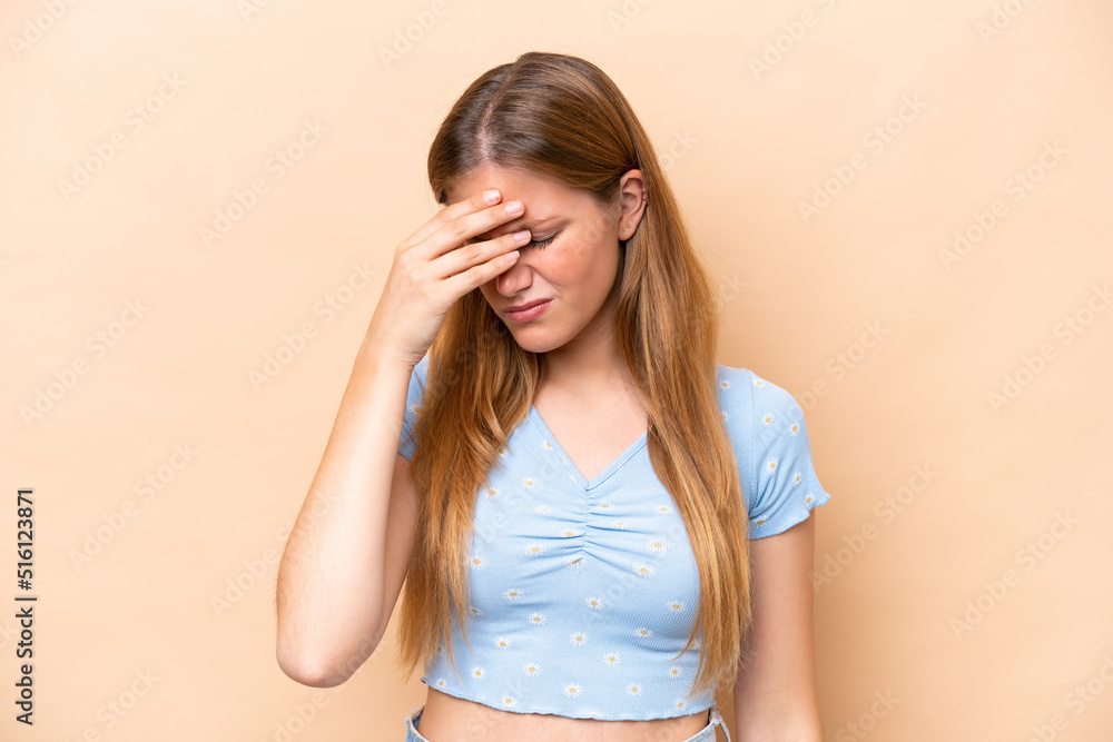 Young caucasian woman isolated on beige background with headache Young caucasian woman isolated on beige background with headache