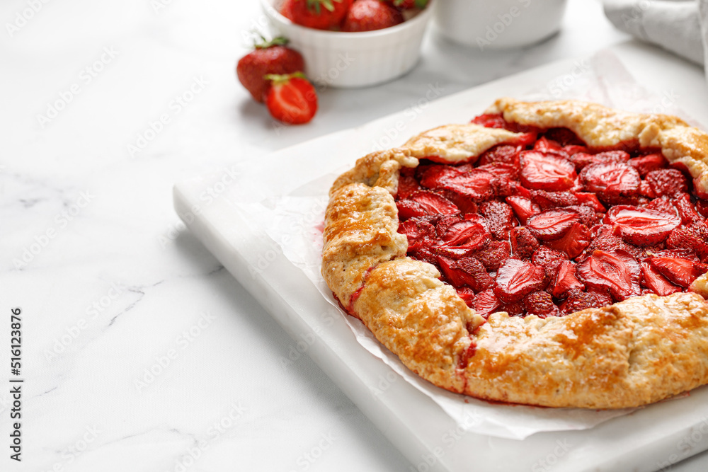 Open strawberry pie on marble board. Strawberry galette. Homemade pastry, baked cake with strawberry. Copy space, text. Open strawberry pie on marble board. Strawberry galette. Homemade pastry, baked cake with strawberry. Copy space, text.