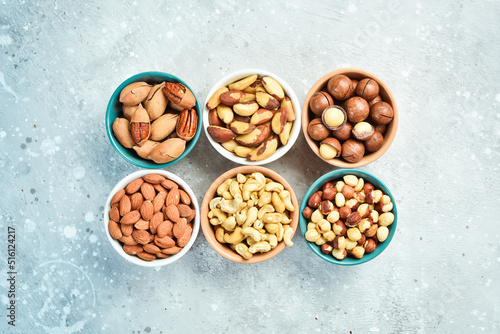 Assortment of nuts: almonds, hazelnuts, cashews and macadamia nuts and pecans. Walnut background. On a stone background.
