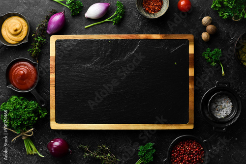 Fototapeta Naklejka Na Ścianę i Meble -  Kitchen slate black board. On a black stone background. Top view.