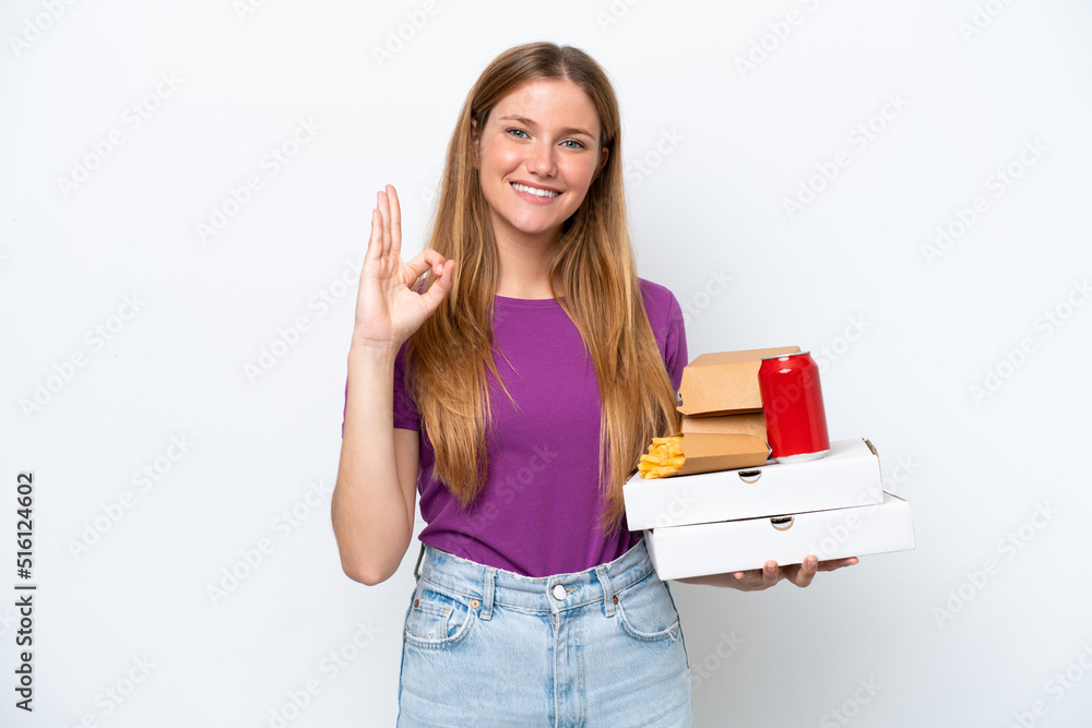 Young pretty blonde woman holding fast food isolated on white background showing ok sign with fingers Young pretty blonde woman holding fast food isolated on white background showing ok sign with fingers