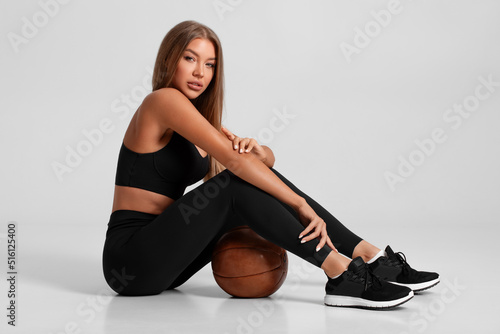 Sexy fitness woman. Beautiful athletic girl, isolated on the gray background photo