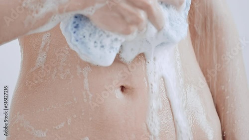 unrecognizable caucasian woman take shower foam flows down the slim stomach slim female with athletic body take a bath