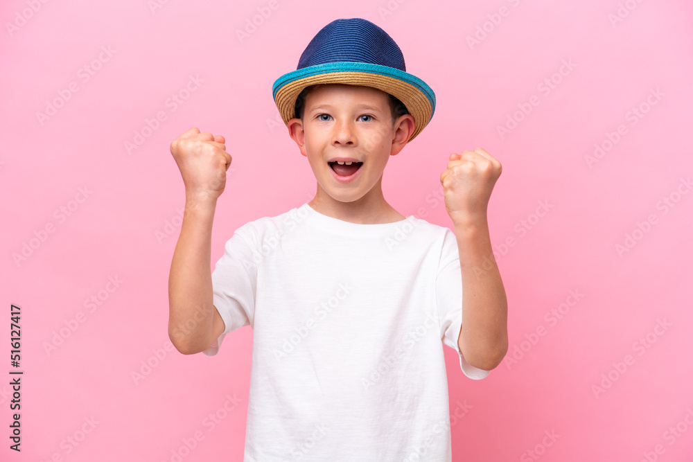 Little caucasian boy wearing a hat isolated on pink background celebrating a victory Little caucasian boy wearing a hat isolated on pink background celebrating a victory