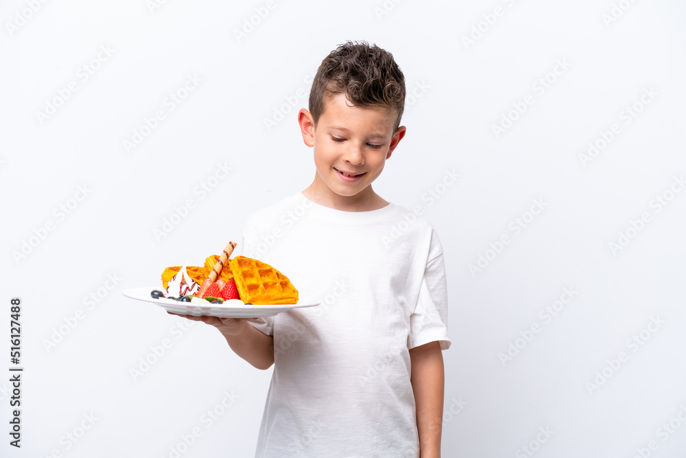 Little caucasian boy holding a waffles isolated on white background with happy expression Little caucasian boy holding a waffles isolated on white background with happy expression