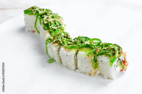 Traditional Japanese sushi rolls on a white plate. Top view. Asian food. On a white background.