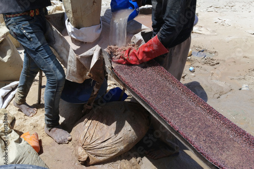 Artisanal miners producing gold in Chami, Mauritania. The ore is mixed with water and the heavy particles of gold are retained by the carpet. The rest is treated with mercury.