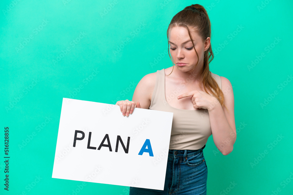 Young caucasian woman isolated on green background holding a placard with the message PLAN A and pointing it Young caucasian woman isolated on green background holding a placard with the message PLAN A and pointing it