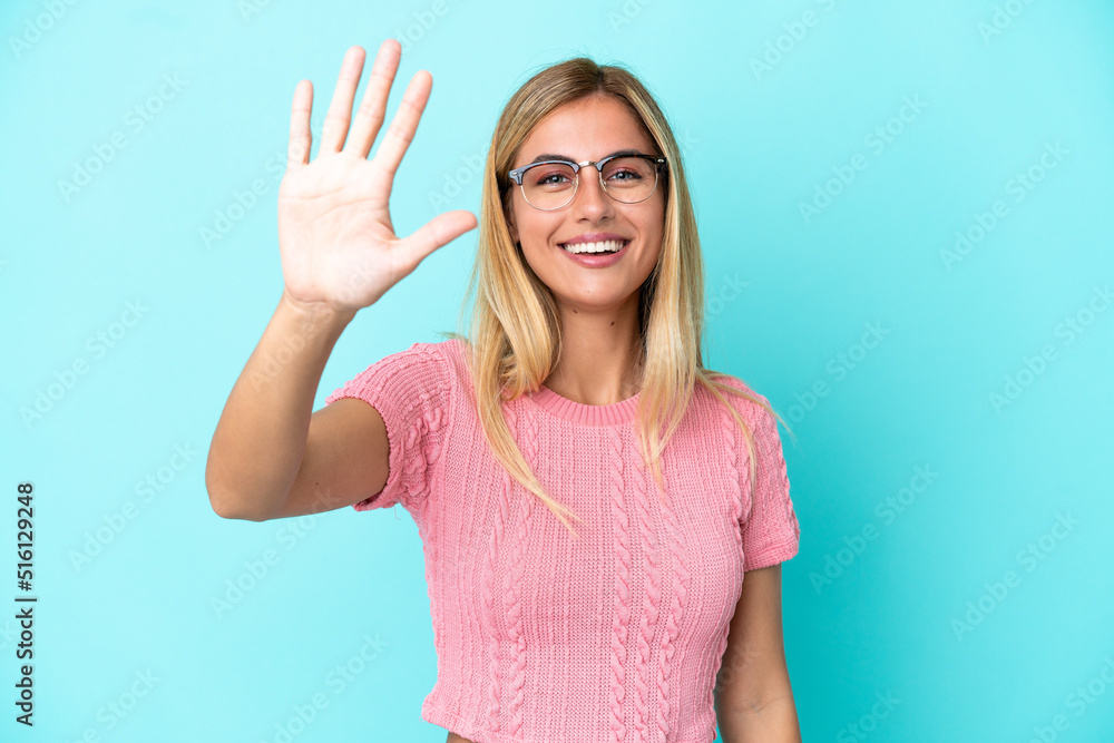 Blonde Uruguayan girl isolated on blue background counting five with fingers Blonde Uruguayan girl isolated on blue background counting five with fingers