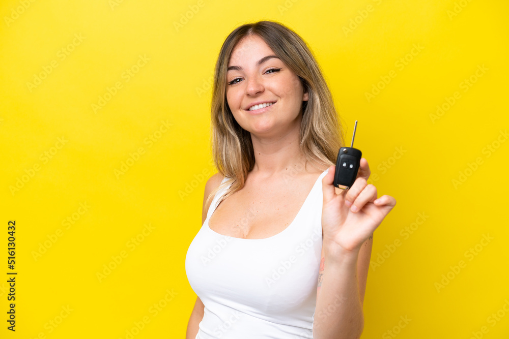 Young woman holding car keys isolated on yellow background with happy expression Young woman holding car keys isolated on yellow background with happy expression