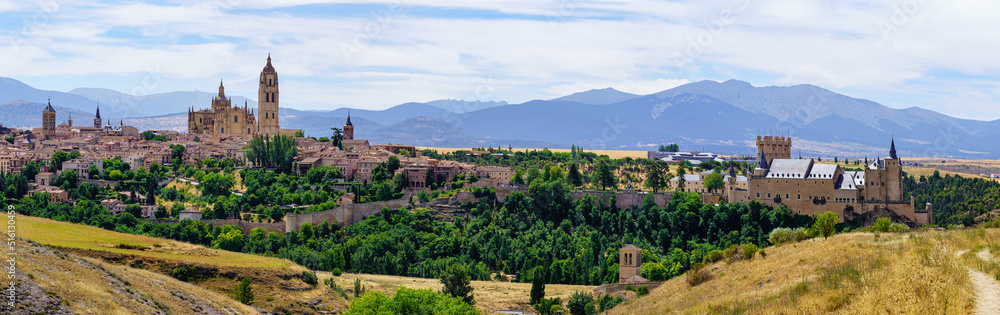 Panoramic view of the medieval city of Segovia with its old buildings and the mountains of Navacerrada in the background.