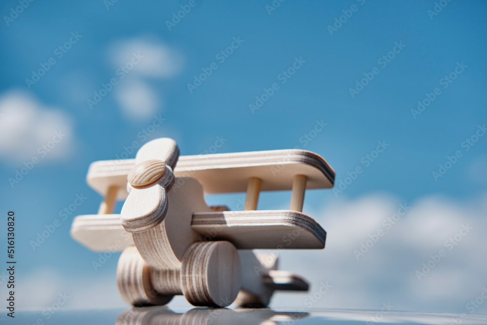 Wooden toy light aircraft biplane over background of cloudy sky. Wooden toy light aircraft biplane over background of cloudy sky.