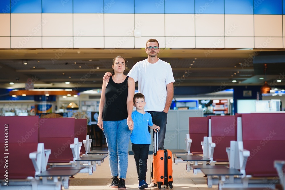 Portrait of traveling family with suitcases in airport