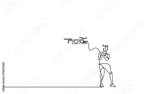 a young male is controlling his drone with a remote and having fun