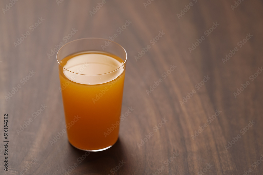 Fresh orange juice in thin glass on wooden table with copy space Fresh orange juice in thin glass on wooden table with copy space