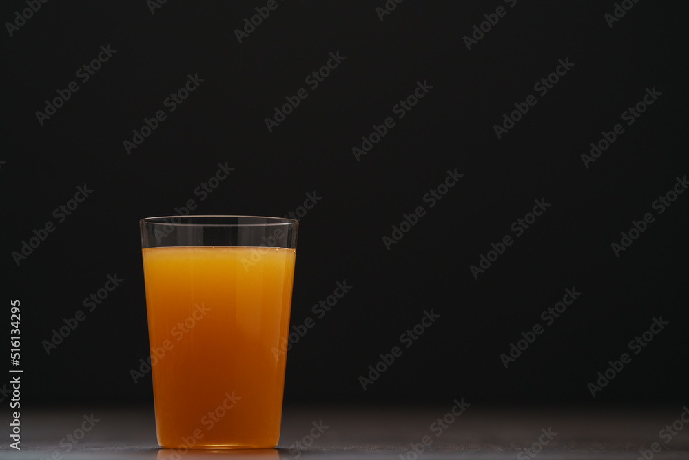 Fresh orange juice in thin glass on wooden table with copy space Fresh orange juice in thin glass on wooden table with copy space