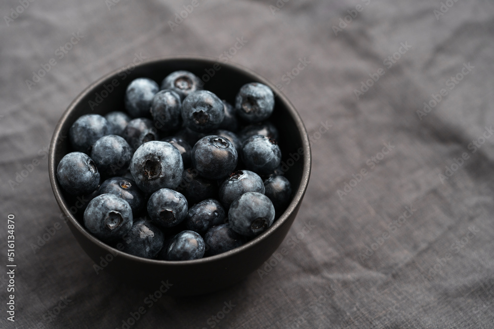 Freshly washed organic blueberries in a black bowl closeup Freshly washed organic blueberries in a black bowl closeup