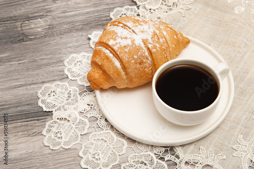 Fototapeta Naklejka Na Ścianę i Meble -  Croissant and coffee cup on saucer top view