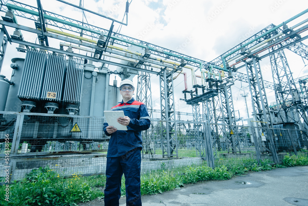 An energy engineer inspects the modern equipment of an electrical substation before commissioning. Energy and industry. Scheduled repair of electrical equipment. An energy engineer inspects the modern equipment of an electrical substation before commissioning. Energy and industry. Scheduled repair of electrical equipment.