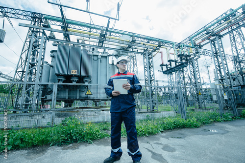 An energy engineer inspects the modern equipment of an electrical substation before commissioning. Energy and industry. Scheduled repair of electrical equipment.