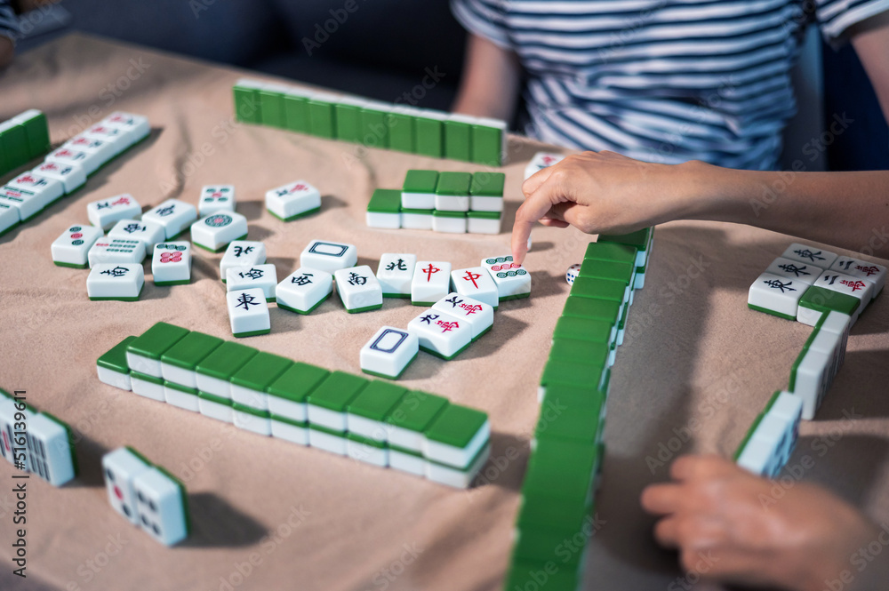Women playing mahjong traditional Chinese board game at home