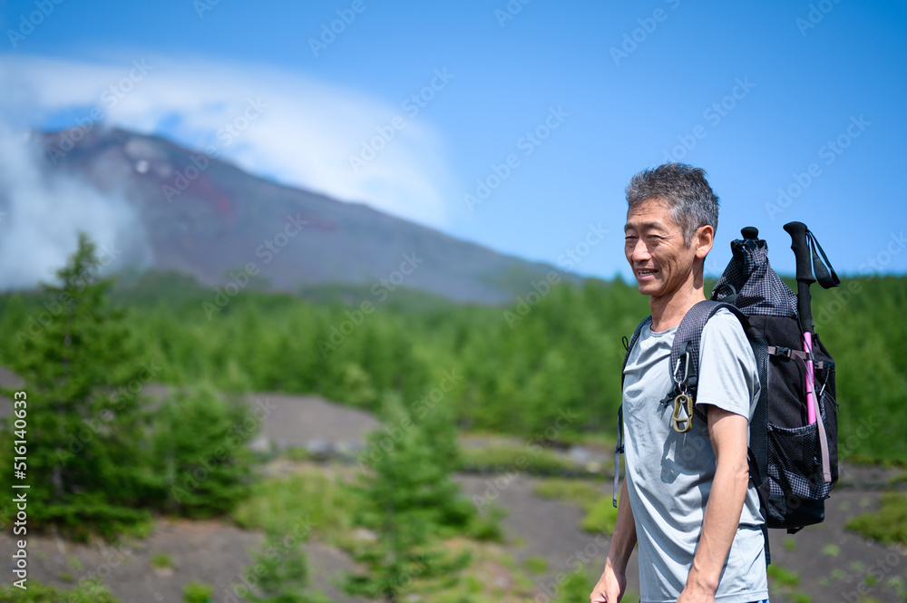 笑顔で富士山登山に挑戦するシニア男性

