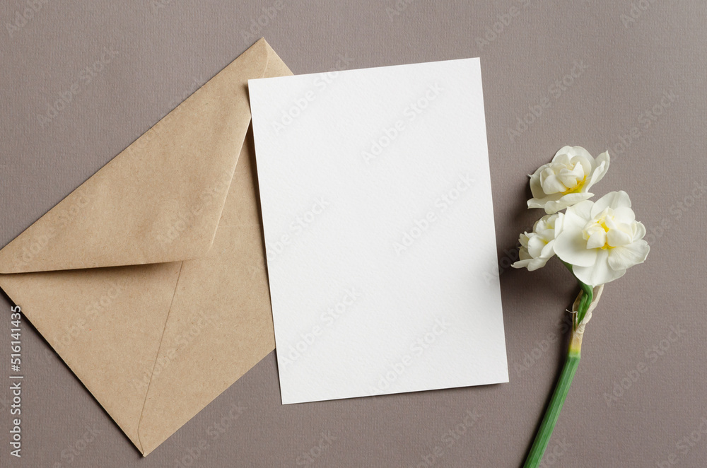 Blank greeting card mockup with envelope and daffodils flowers Blank greeting card mockup with envelope and daffodils flowers