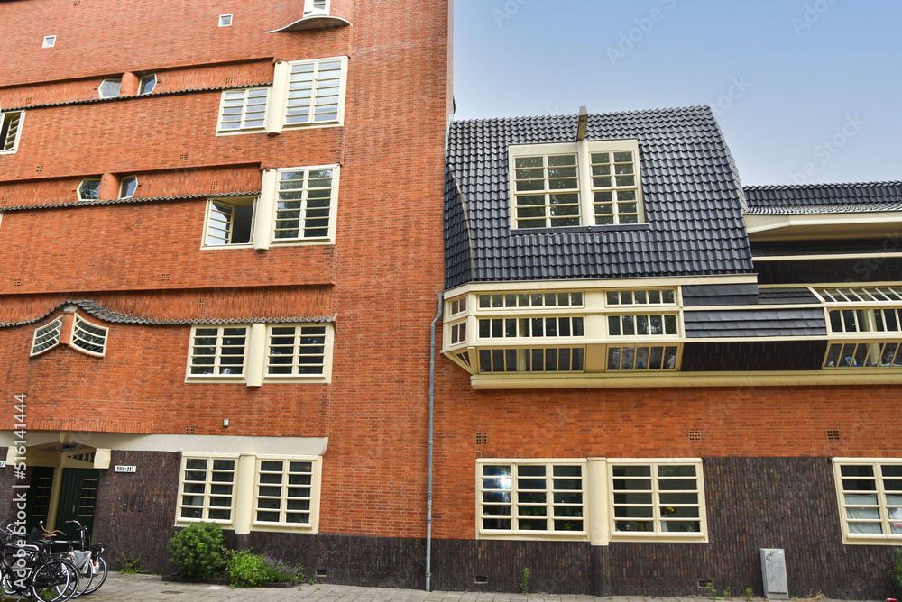 Fototapeta premium Amsterdam, Netherlands. June 2022. Details and facades of characteristic brick construction of residential building in Amsterdam School style architecture in Spaarndammerbuurt neighborhood