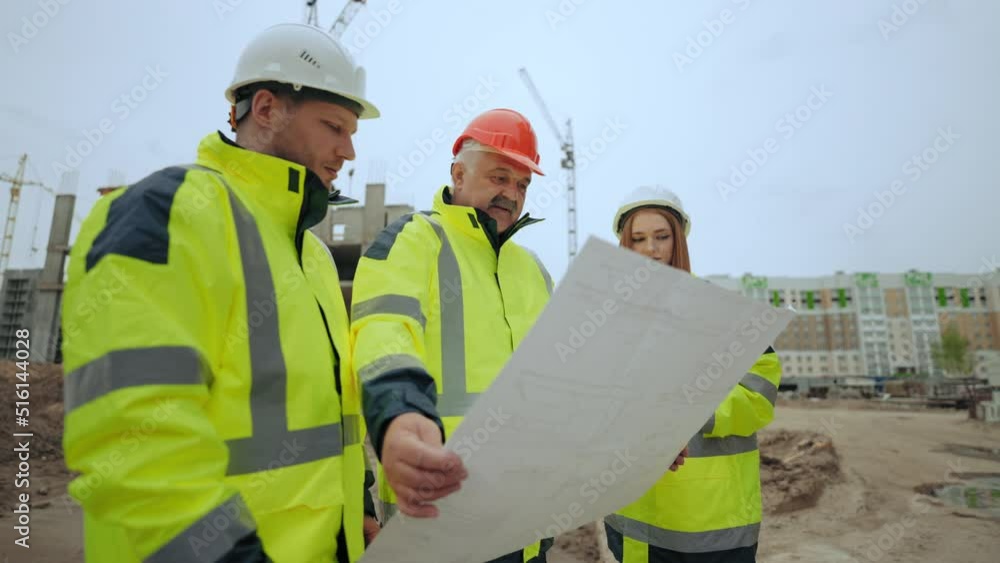 group of builders and engineers are inspecting construction plan of new object in building site group of builders and engineers are inspecting construction plan of new object in building site