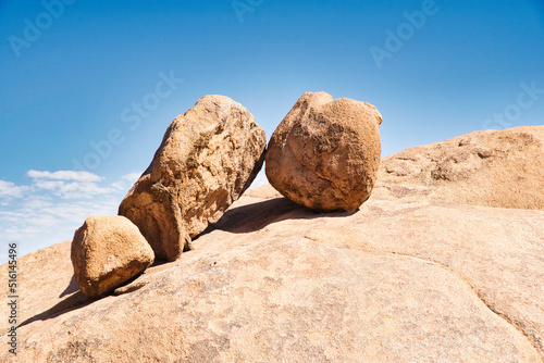 Three big rocks leaning against each other, looking like toys and defying gravity. Impressive nature scene in Spitzkoppe National Park, Namibia. 