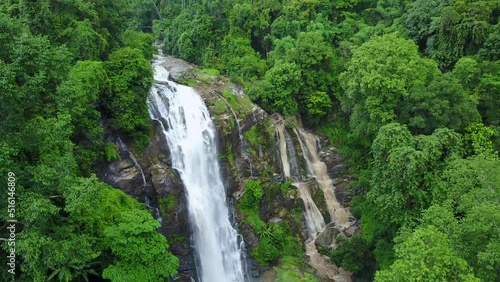 Aerial view from drone of Wachirathan Waterfalls, beautiful waterfall flowing from high cliff around with green forest background, Doi Inthanon National Park, Chiang Mai, northern Thailand.