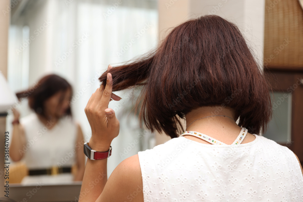 Fototapeta premium 鏡の前に座る女性の後ろ姿