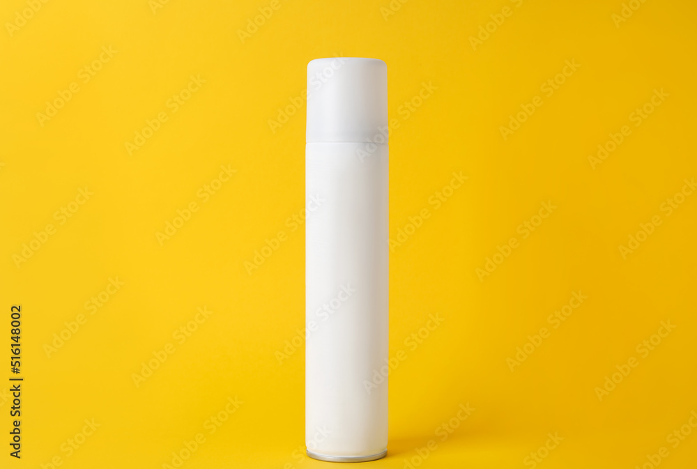 Bottle of dry shampoo on yellow background Bottle of dry shampoo on yellow background