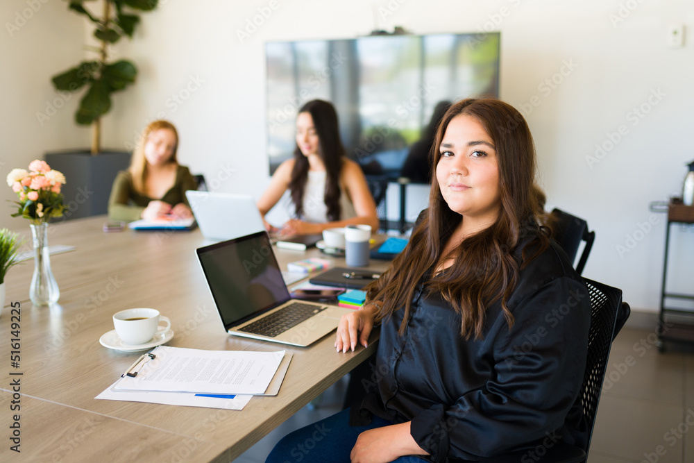 Portrait of a latin obese woman taking notes at a work meeting Portrait of a latin obese woman taking notes at a work meeting