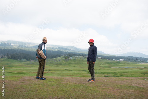 Rear view portrait of young indian guy with red hat and standing outdoors with arms spread open. © 3 Travelers
